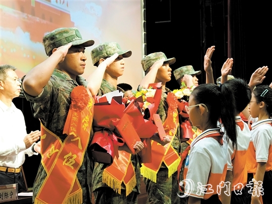 小學(xué)生代表向入伍新兵代表獻(xiàn)上鮮花。