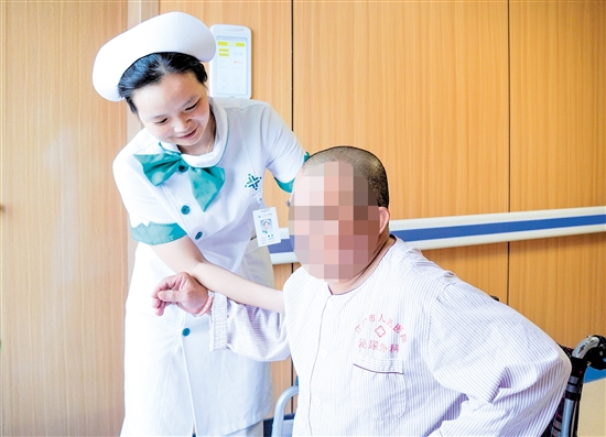 護(hù)士攙扶雙下肢無(wú)力患者上病床。