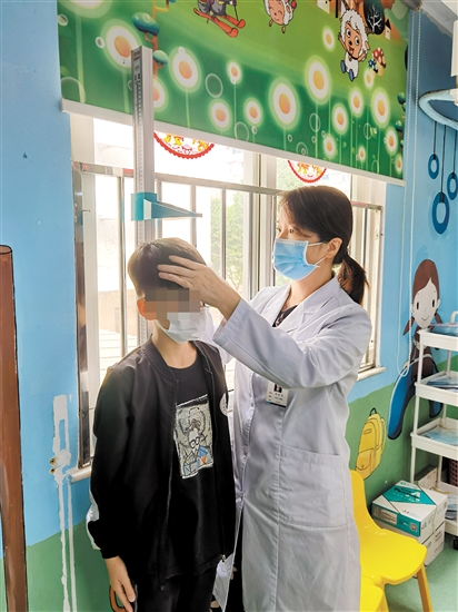 醫(yī)生為兒童量身高。