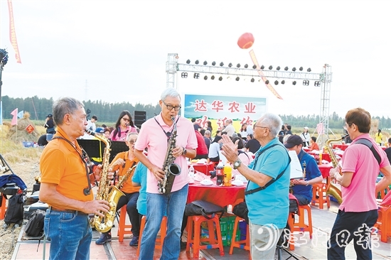 表演人員在稻田里吹響薩克斯風，與澳門禮樂鄉(xiāng)親齊慶豐收。