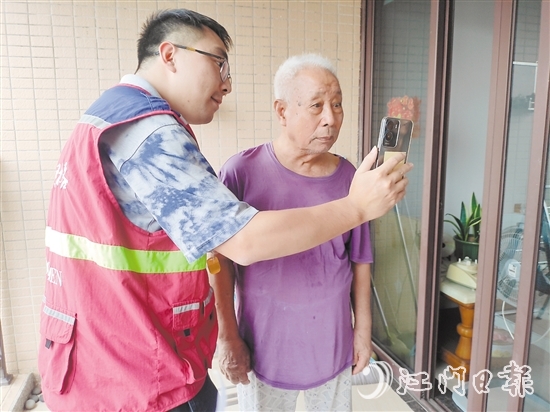 老年人在志愿者幫助下與親人視頻通話。
