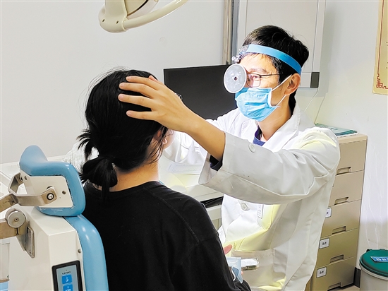 醫(yī)生為患者檢查鼻子。