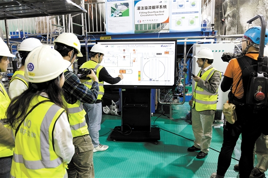 12月18日，江門中微子實(shí)驗(yàn)項(xiàng)目經(jīng)理王貽芳院士（右二）和科研人員一起啟動(dòng)液體灌注。