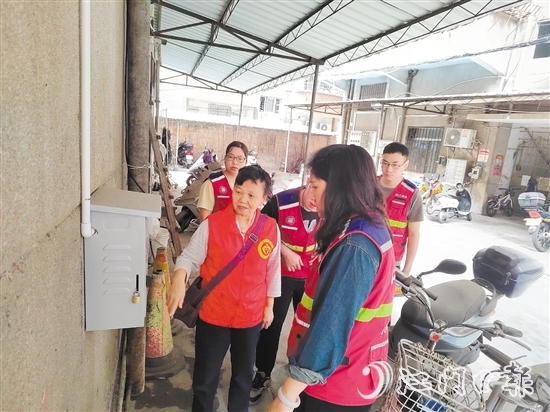 退休黨員干部鄧玉歡與網(wǎng)格員一起就充電樁選址開展調(diào)研。