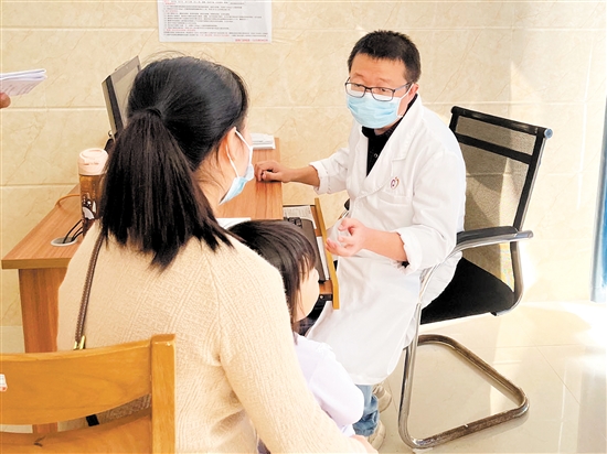 醫(yī)生正在接診呼吸道疾病患兒。