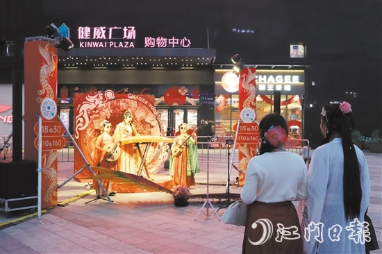 在健威廣場(chǎng)，身穿漢服的市民駐足欣賞國(guó)潮音樂表演。