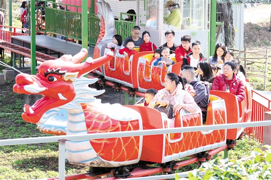 在位于江海區(qū)的江門長廊生態(tài)園，市民游客坐上小火車，享受闔家歡樂時光。