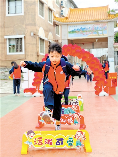 蓬江區(qū)荷塘鎮(zhèn)聯(lián)育小學(xué)學(xué)生跨過吉祥欄。