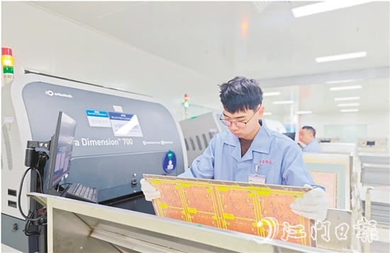 在鶴山中富生產(chǎn)車間，員工操作自動化設(shè)備趕制電路板。