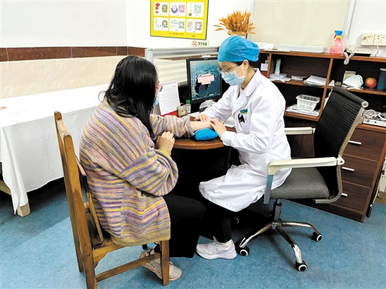 周春華向患者了解情況。