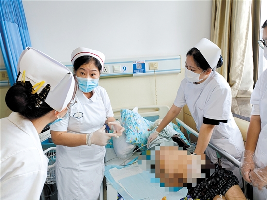朱敏林（中）與同事對(duì)患者進(jìn)行護(hù)理服務(wù)。