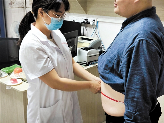 醫(yī)生為記者測(cè)量腰圍。