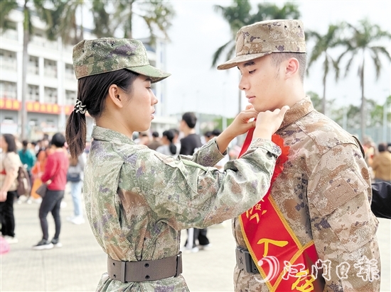在歡送儀式現(xiàn)場，老兵姐姐為新兵弟弟整理軍裝。