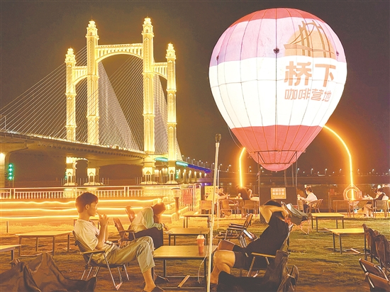 夜幕降臨，潭江兩岸燈火闌珊，市民、游客在“橋下咖啡營(yíng)地”品咖啡、賞夜景，享受愜意時(shí)光。