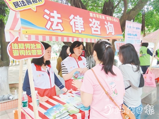 在法律援助攤位，司法系統(tǒng)黨員志愿者耐心解答群眾的法律咨詢。