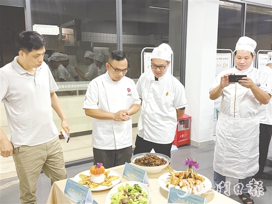 伍立更（左二）對(duì)學(xué)員們的自創(chuàng)菜式一一進(jìn)行點(diǎn)評(píng)和指導(dǎo)。