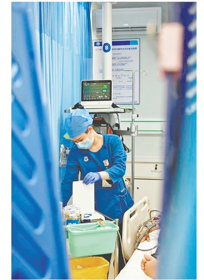 這是一雙爭(zhēng)分奪秒的手。急診搶救室是與時(shí)間賽跑的“生命戰(zhàn)場(chǎng)”，收治的都是急危重癥患者，生死往往就在一瞬間。面對(duì)心梗病人，江門市中心醫(yī)院急診科護(hù)士譚秀娟正專心致志地為患者做心電圖檢查，用專業(yè)與仁心守護(hù)生命之光。