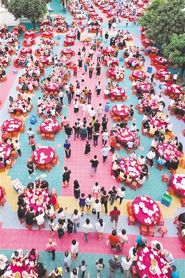 蓬江區(qū)棠下鎮(zhèn)大林村的村民看完龍舟賽后，相聚共食龍舟飯。郭永樂