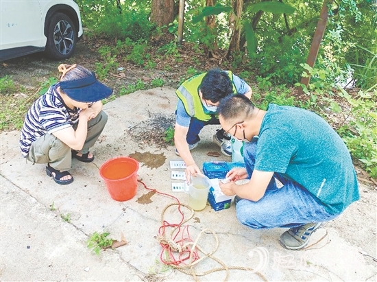 巡河過程中，工作人員沿河查看并采集水樣進行檢測。