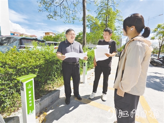 余中宏（左一）與同事一起查看“民生服務充電站”項目建設進度。