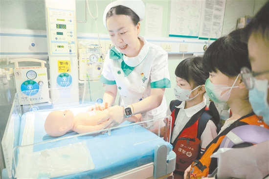 醫(yī)護人員為小記者演示新生兒輻射保暖臺的用途。 醫(yī)護人員為小記者演示新生兒輻射保暖臺的用途。