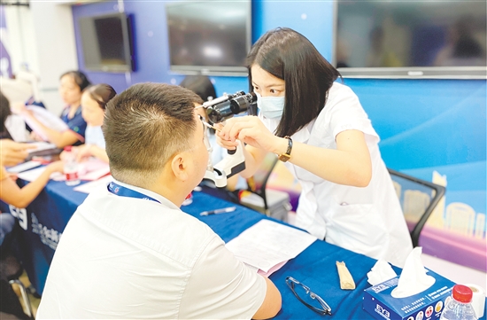 醫(yī)護(hù)人員為企業(yè)職工檢查眼睛。