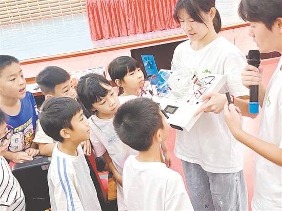 服務(wù)隊(duì)隊(duì)員向孩子們展示氫燃料電池演示儀。