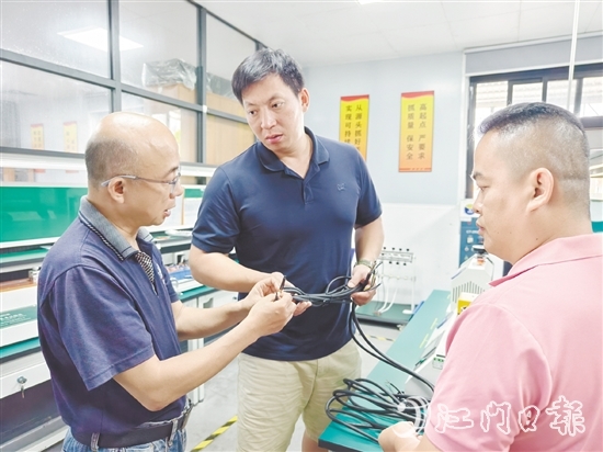 盧慶忠（中）與技術(shù)人員交流產(chǎn)品質(zhì)量問題。