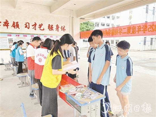 工作人員向?qū)W生宣傳防溺水知識。