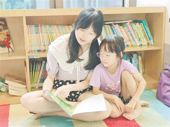 在龍溪湖閱讀中心，一位家長(zhǎng)正陪伴孩子讀繪本。