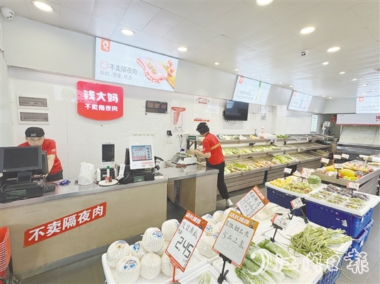 錢大媽生鮮店的工作人員正在線上接單并準備菜品。