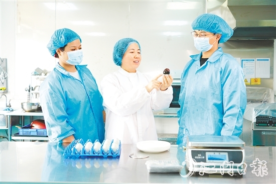 在培訓(xùn)室里，梁艷芬（中間白衣）和大家交流蛋品檢測方式。