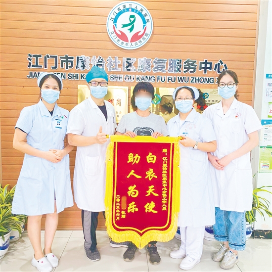 李明給康復(fù)中心醫(yī)護(hù)人員送上錦旗。