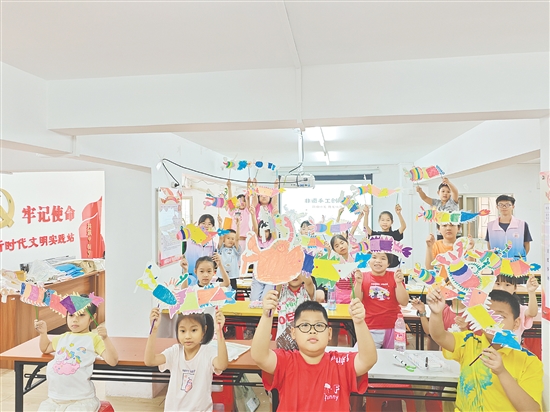 孩子們手持自制荷塘紗龍一起合照，課堂變民俗小舞臺(tái)。