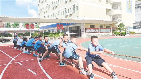 參賽隊(duì)員們緊握長繩，齊心協(xié)力，鼓足勁拼命往后拉。