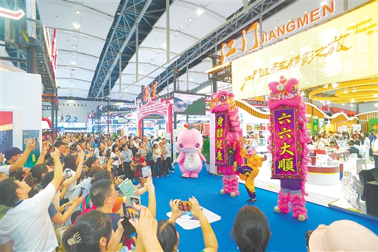 江門展館內(nèi)，醒獅騰躍的精彩表演引得參觀者紛紛舉起手機(jī)，定格這熱鬧瞬間。