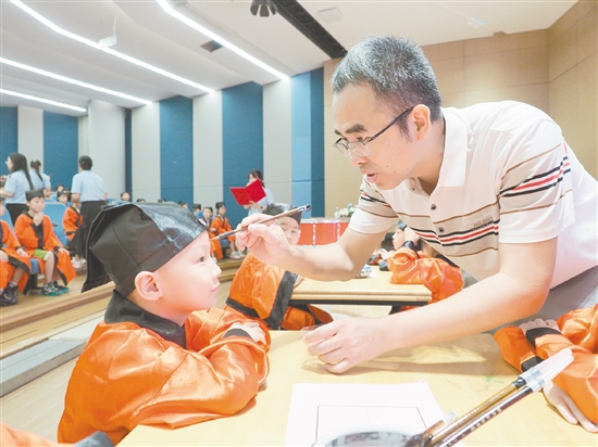 在朱砂啟智環(huán)節(jié)，教師用毛筆在新生的額頭點(diǎn)上紅痣。