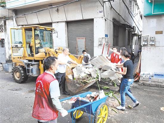 在蓬江區(qū)環(huán)市街道里村社區(qū)舊村片區(qū)，人和機(jī)器齊上陣，清理衛(wèi)生死角。