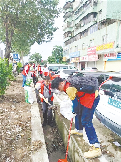 黨員防疫突擊隊(duì)隊(duì)員在開平市長(zhǎng)沙街道南島社區(qū)清理垃圾。