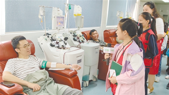 小記者采訪正在獻(xiàn)血的志愿者。