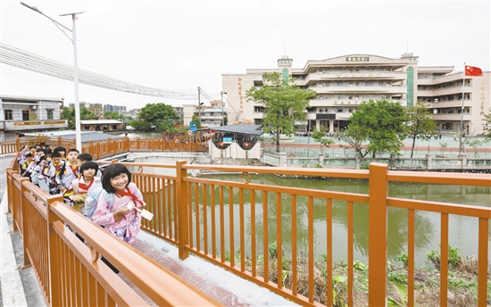 雙橋小學(xué)的學(xué)生放學(xué)后在新修建的步道上結(jié)伴而行，身旁的車流被欄桿有效隔離，構(gòu)筑起校園交通的安全防線。