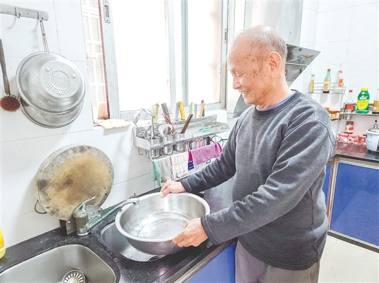榕樹村村民麥成建在廚房用干凈的自來水清洗餐具。