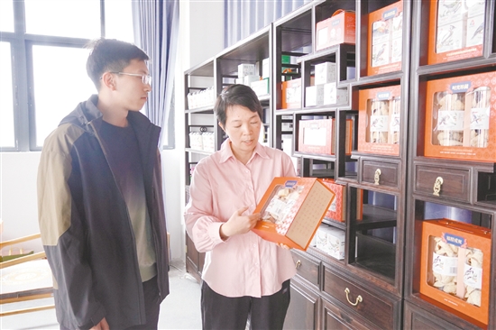 江門農(nóng)商銀行工作人員（左）走訪李樣講（廣東）陳皮有限公司。