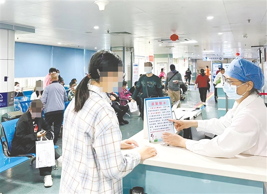 醫(yī)護(hù)人員向市民介紹“一次掛號管一次就醫(yī)流程”相關(guān)內(nèi)容。