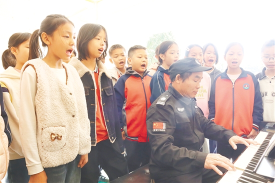 良山小學(xué)的保安陸木養(yǎng)彈奏鋼琴，學(xué)生們隨著旋律歡快唱歌。