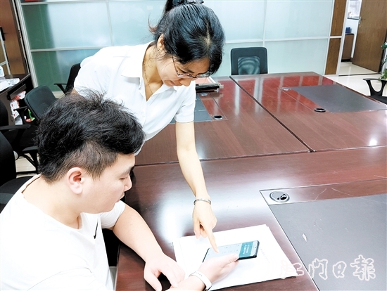 工作人員在指導市民線上交存住宅專項維修資金。陸沿任