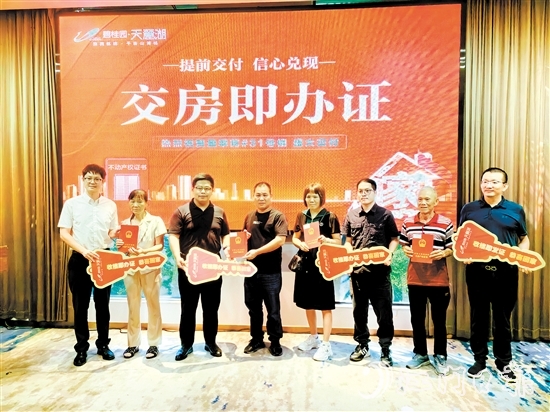 業(yè)主喜拿房產(chǎn)證和鑰匙。