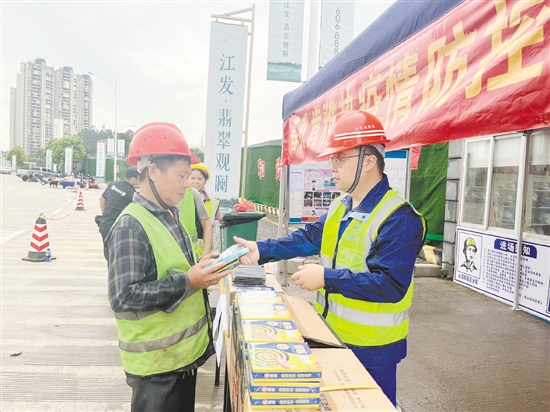 工地施工人員排隊(duì)領(lǐng)取防蚊用品。