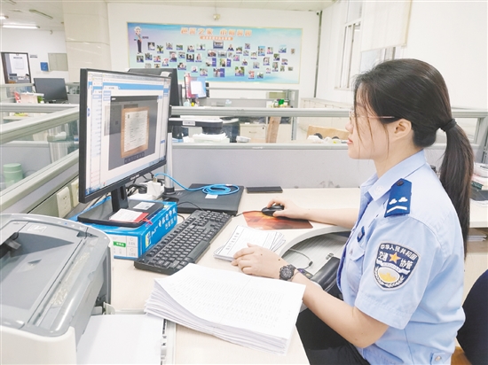 車管所網(wǎng)辦中心工作人員在對用戶提交的資料進行審核。